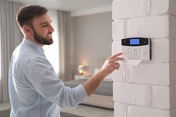 Hombre activando un sistema de alarma en casa